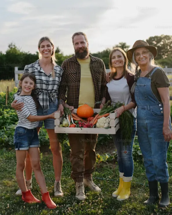 Famiglia nell'orto con una cassetta di verdure appena raccolte
